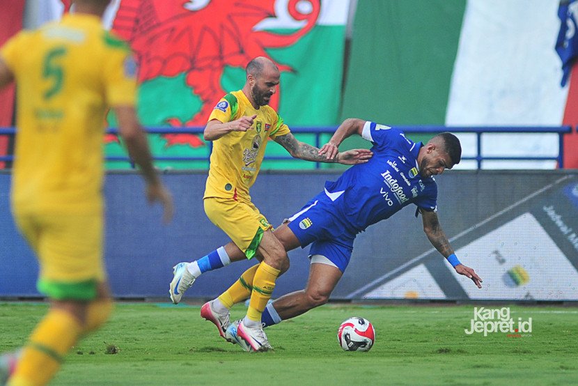 Winger Persib Bandung  Berguinho dilanggar Persebaya Surabaya berebut bola pada laga ke-4 BRI Superleague pekan ke-4 di Stadion Gelora Bandung Lautan Api pada Jumat (12/9/2025) sore WIB. (KANGJEPRET.ID/ YOGI ARDHI) (Data: Nikon D700, Nikkor MF 300/2.8) 