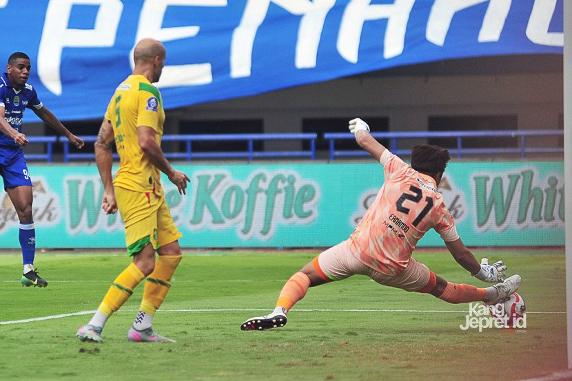 Kiper Persebaya Surabaya Ernando Ari Sutaryadi berusaha memhalau bola tendangan striker Persib Bandung Uilliam Barros dilanggar Persebaya Surabaya berebut bola pada laga ke-4 BRI Superleague pekan ke-4 di Stadion Gelora Bandung Lautan Api pada Jumat (12/9/2025) sore WIB. (KANGJEPRET.ID/ YOGI ARDHI) (Data: Nikon D700, Nikkor MF 300/2.8) 