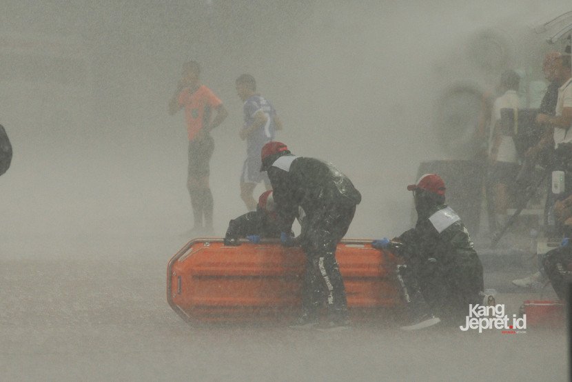 Wasit Candra dan tim kedua kesebelasan meninggalkan lapangan ketika laga Persib vs Persebaya dihentikan akibat hujan deras yang melanda Stadion Gelora Bandung Lautan Api, Bandung, Jumat (12/9/2025). (KANGJEPRET/ YOGI ARDHI) (Data: Nikon D700, Nikkor MF 300/2.8 ED)
