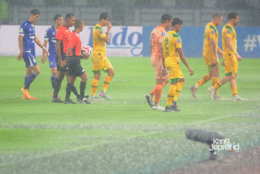 Wasit Candra dan tim kedua kesebelasan meninggalkan lapangan ketika laga Persib vs Persebaya dihentikan akibat hujan deras yang melanda Stadion Gelora Bandung Lautan Api, Bandung, Jumat (12/9/2025). (KANGJEPRET/ YOGI ARDHI) (Data: Nikon D700, Nikkor MF 300/2.8 ED)